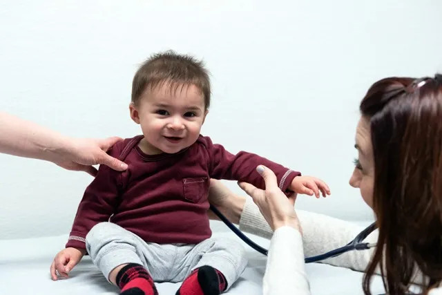 a cute young boy getting an exam by a pediatrician