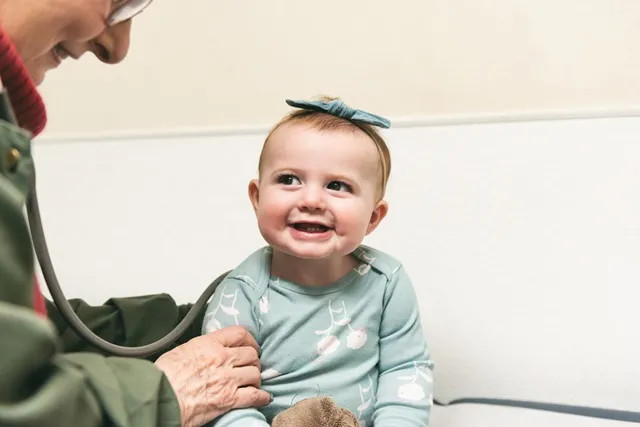 a young girl smiling up at a doctor