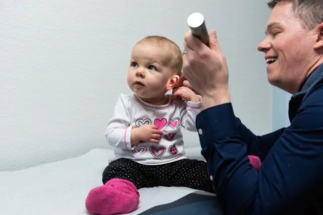 a baby girl getting her ear examined