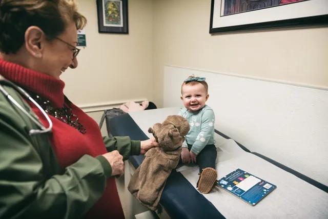 a young infant smiling on the exam table